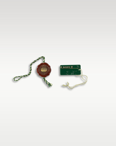 A 2014 era period-correct brown string wax seal tag shown next to the green rectangular factory barcode serial number inventory hangtag