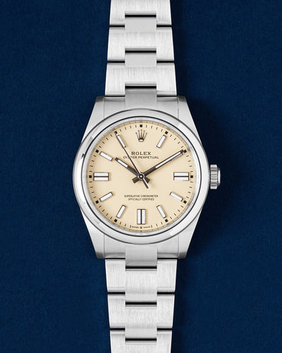 A preowned 2026 Rolex Oyster Perpetual 134300 displaying its original warm beige dial smooth steel bezel and stainless steel Oyster case at Grand Caliber in Dallas, Texas