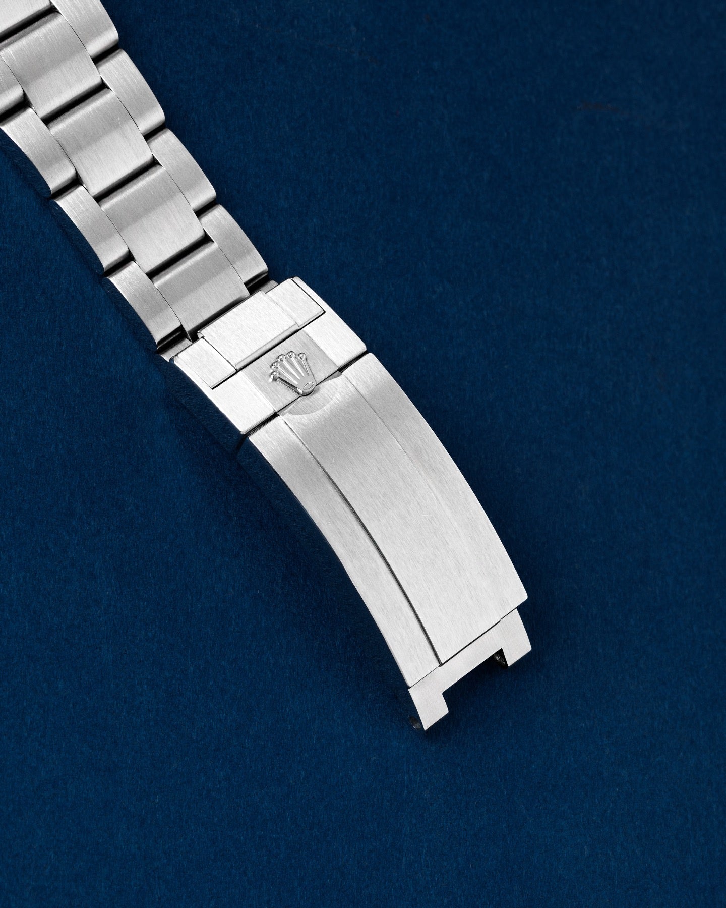 exterior view of a brushed Oystersteel folding Oysterlock safety clasp featuring an embossed Rolex crown logo