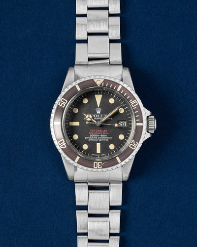 A preowned 1974 Rolex Sea Dweller 1665 displaying its original matte black dial faded bezel insert and classic steel case at Grand Caliber in Dallas, Texas
