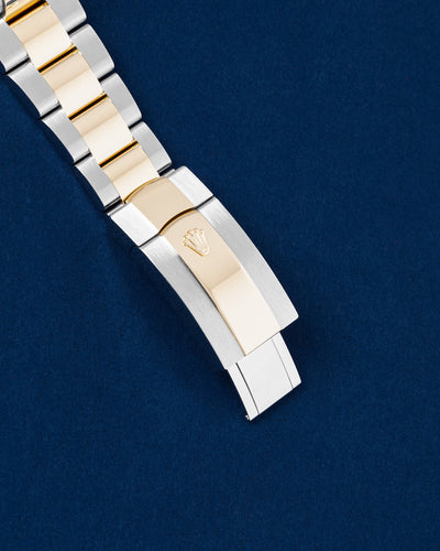 Close-up of the polished 18k yellow gold and brushed Oystersteel folding Oysterclasp on a modern Rolex Sky-Dweller bracelet