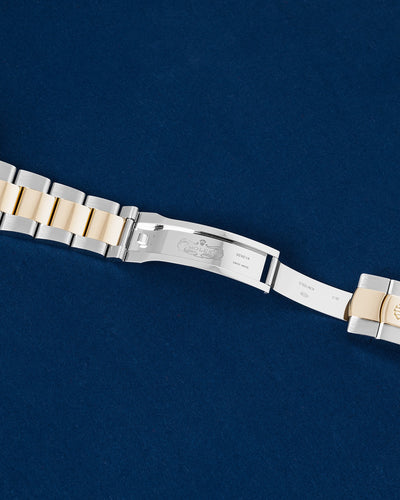 Close-up studio view of the open Rolex folding Oysterclasp mechanism showing inner steel and gold hallmarks
