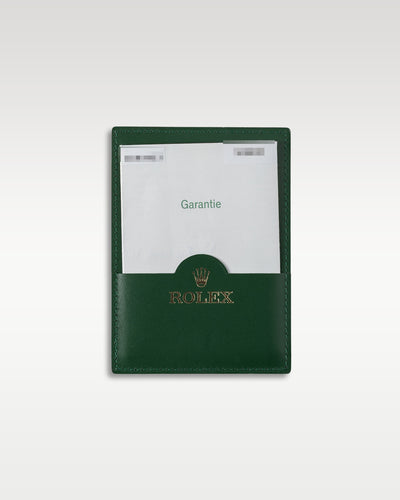 Original punch-paper international guarantee certificate in its green leather wallet for a 2007 Rolex Submariner