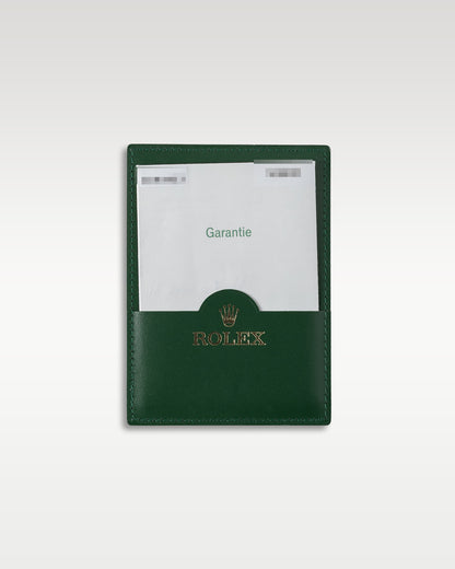 Original punch-paper international guarantee certificate in its green leather wallet for a 2007 Rolex Submariner