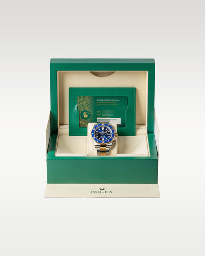 open classic green wave-motif Rolex presentation box displaying a full set with a two-tone Bluesy Submariner watch inside