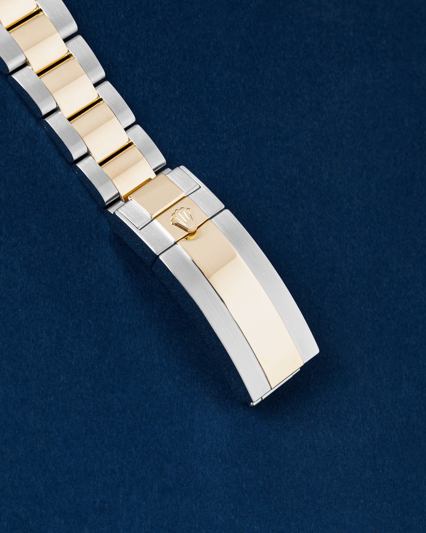 exterior view of a two-tone Oystersteel and 18k yellow gold Oysterlock folding safety clasp with the Rolex crown logo
