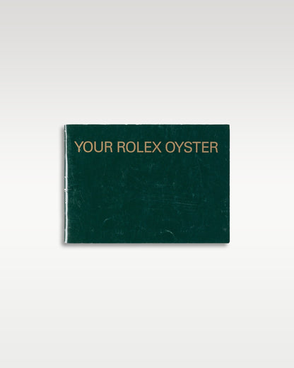classic dark green 'Your Rolex Oyster' general instruction and ownership manual resting flat in a studio layout