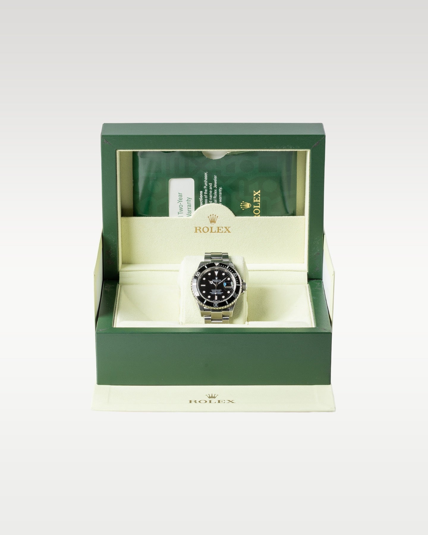 five-digit 2007 Rolex Submariner watch displayed resting upright on its cushion inside the iconic dark green luxury presentation box