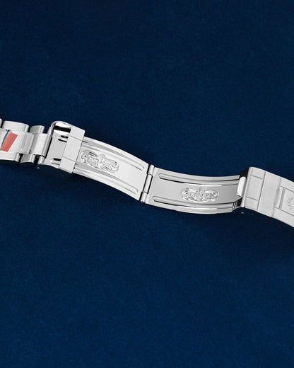 overhead studio portrait view of the fully opened vintage-style stainless steel folding clasp mechanism displaying internal blade hallmarks and dive extension link