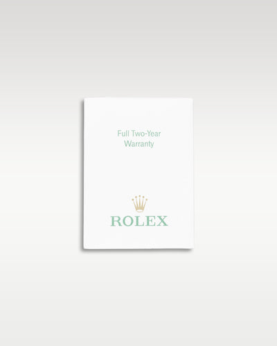 small white paper Rolex factory translation booklet displayed flat against a neutral light studio backdrop