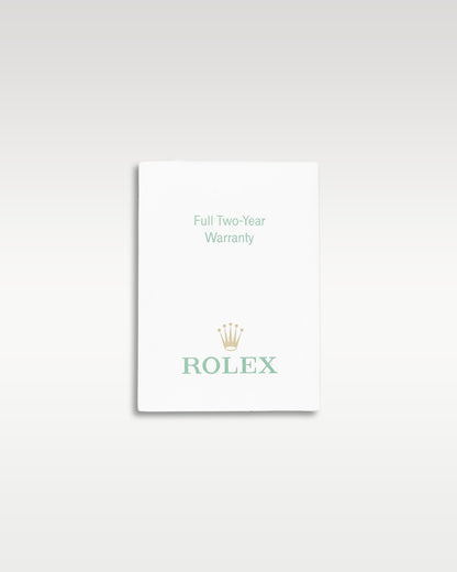 small white paper Rolex factory translation booklet displayed flat against a neutral light studio backdrop