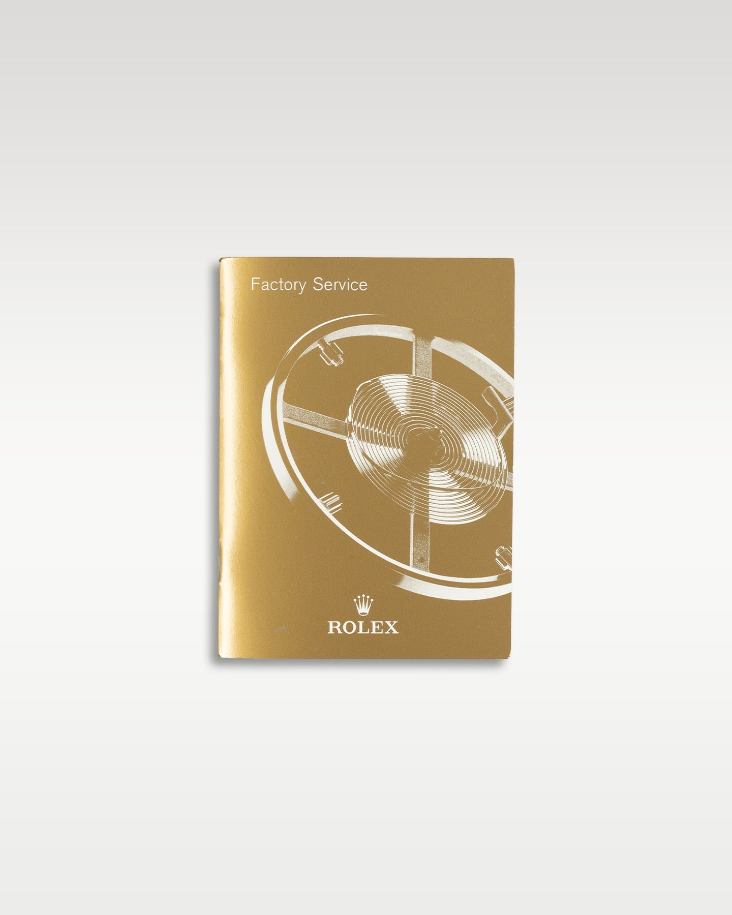 tan-gold covered vintage Rolex factory service booklet and worldwide warranty information pamphlet displayed flat