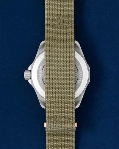 titanium TAG Heuer Aquaracer Solargraph showing the sandblasted caseback completely covered by the khaki green woven NATO fabric strap
