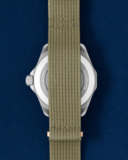 titanium TAG Heuer Aquaracer Solargraph showing the sandblasted caseback completely covered by the khaki green woven NATO fabric strap