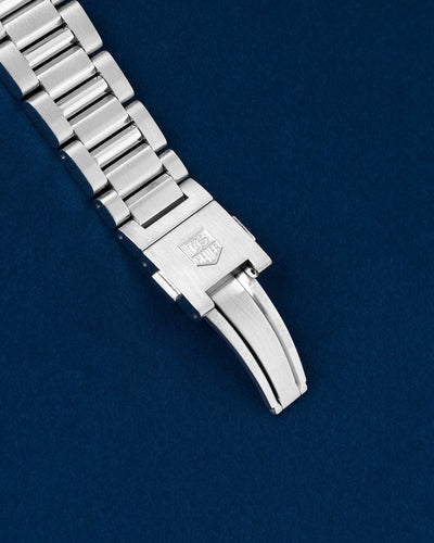 Close-up view of the closed brushed and polished stainless steel folding deployment clasp stamped with the TAG Heuer shield logo