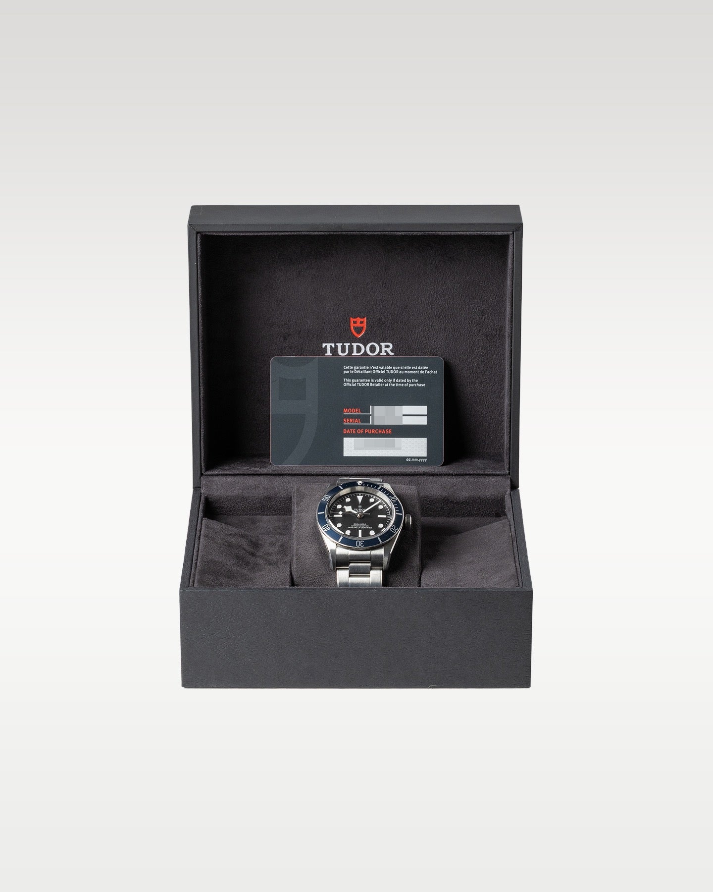 open black textured Tudor presentation box displaying a blue bezel Black Bay 41 automatic diver watch on a watch pillow