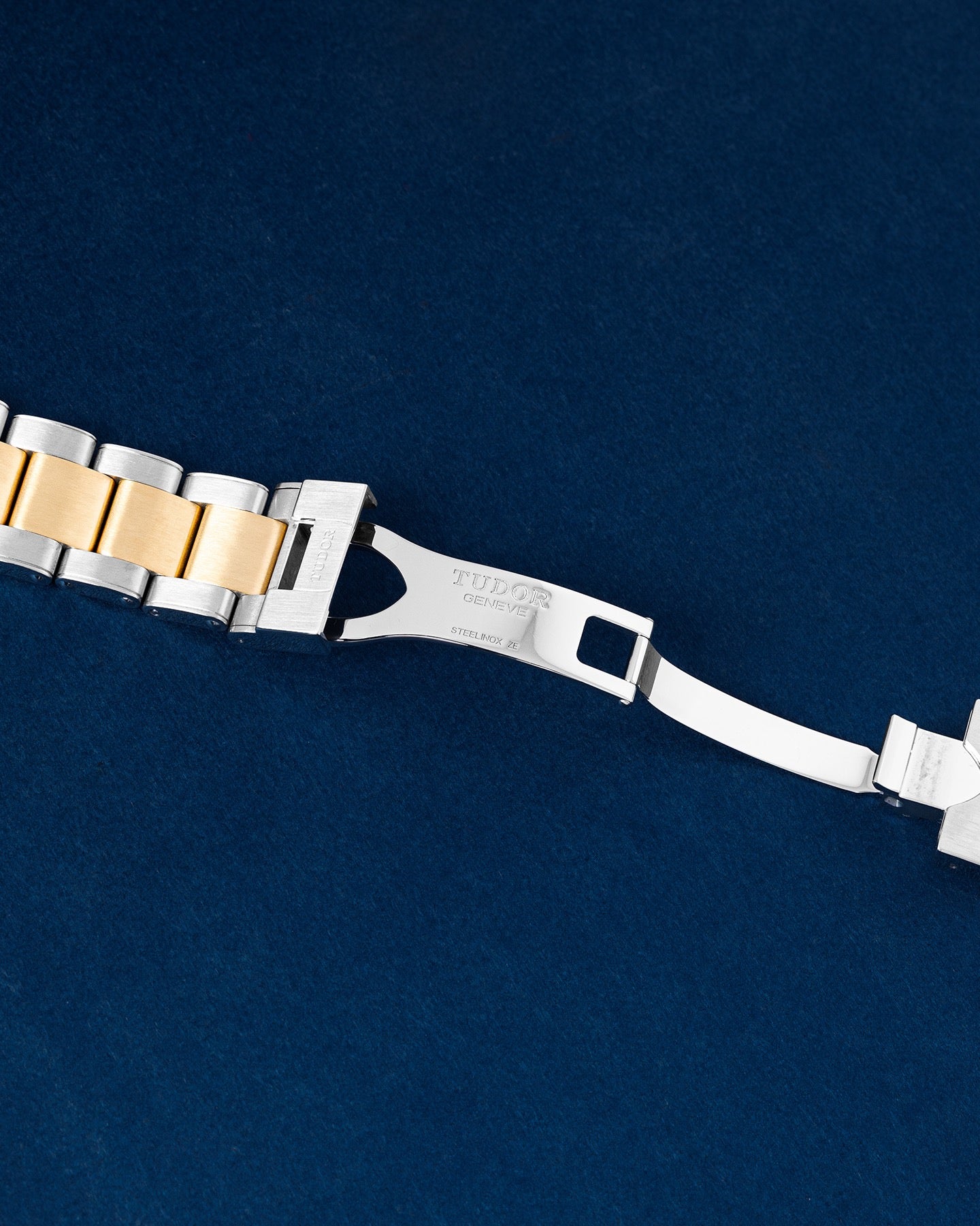exterior folding stainless steel safety clasp attached to a two-tone steel and yellow gold capped watch bracelet