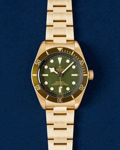 Brand new 2025 solid 18k yellow gold Tudor Black Bay 58 reference M79018V featuring a matte olive green dial and matching green aluminum timing bezel at Grand Caliber in Dallas