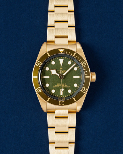 Brand new 2025 solid 18k yellow gold Tudor Black Bay 58 reference M79018V featuring a matte olive green dial and matching green aluminum timing bezel at Grand Caliber in Dallas