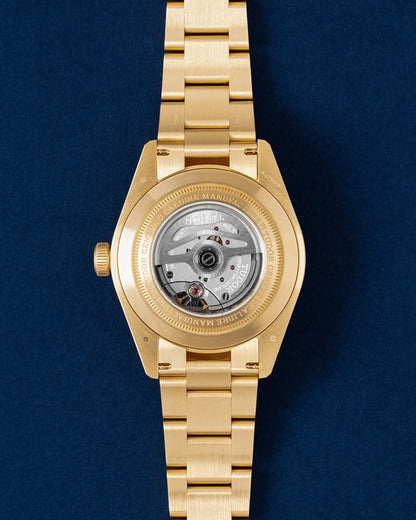 Rear profile of the 18k yellow gold watch head showing the open exhibition sapphire crystal caseback displaying the automatic manufacture caliber MT5400 movement
