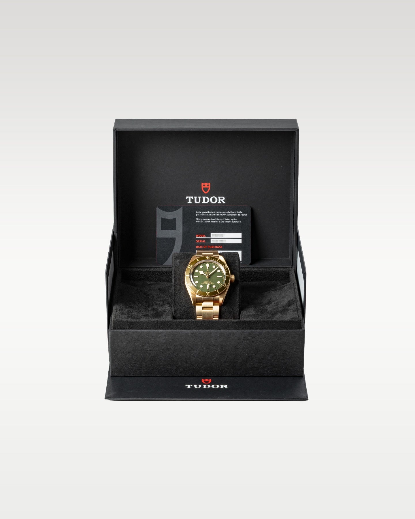 The complete retail presentation package of an unworn solid 18k gold Tudor Black Bay 58 timepiece resting securely within its inner textured black watch chest
