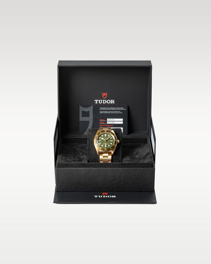The complete retail presentation package of an unworn solid 18k gold Tudor Black Bay 58 timepiece resting securely within its inner textured black watch chest
