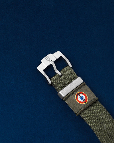 Close-up of the Tudor green fabric strap showcasing the titanium tang buckle and the French Naval Aviation roundel insignia emblem