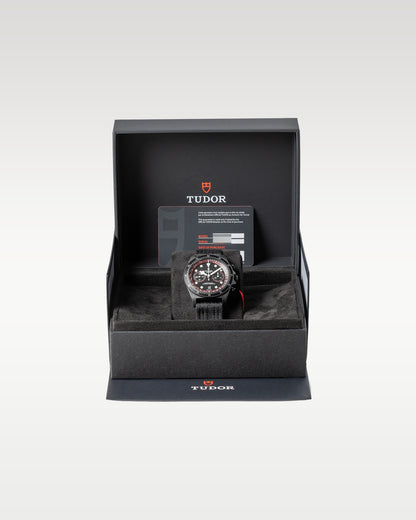 open black textured Tudor presentation watch box securely displaying a carbon composite Pelagos FXD Chrono watch inside