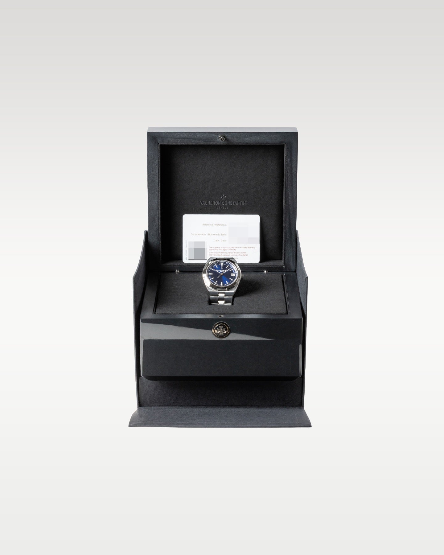 open dark grey textured Vacheron Constantin luxury watch box safely displaying a blue dial Overseas 4500V watch inside