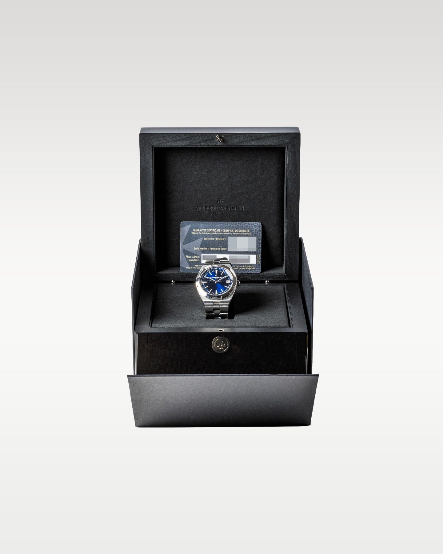 open dark grey textured Vacheron Constantin luxury watch box displaying a blue dial Overseas 4500V watch inside