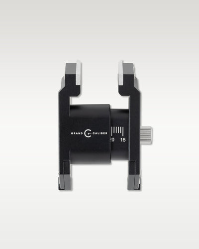 Overhead detail shot of a black Grand Caliber watchmaker casing tool showing dual adjustable clamp jaws and knurled side dial