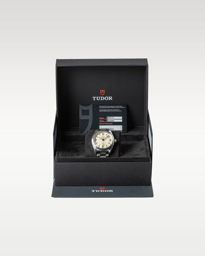 open black textured Tudor presentation box displaying a cream dial Ranger automatic field watch on a watch pillow