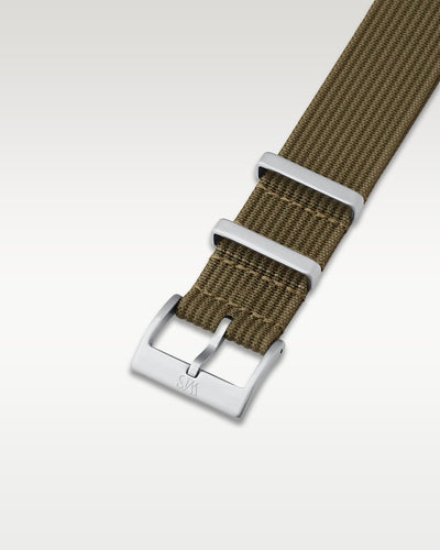 Angled detail shot of a olive military green nylon watch band showing its pre-installed brushed pin buckle