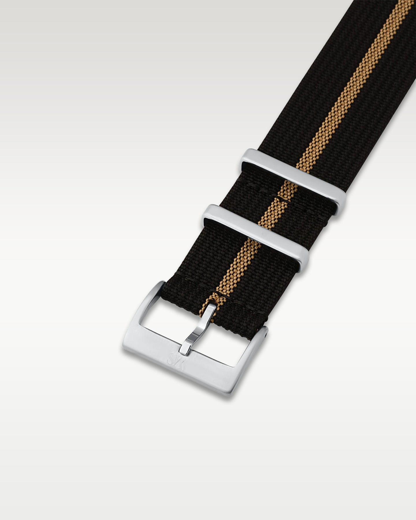 Angled detail shot of a black and khaki striped nylon watch band showing its pre-installed brushed silver pin buckle