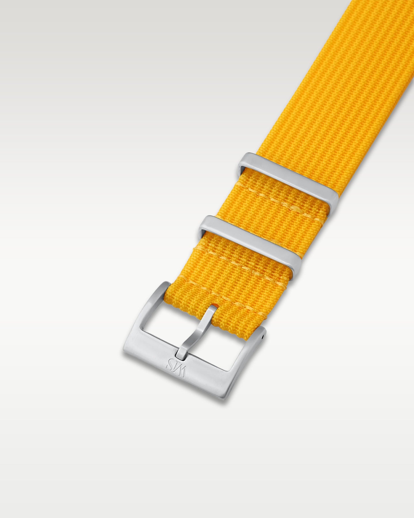 Angled detail view of a vibrant lemon yellow nylon watch band showcasing its brushed silver pin buckle