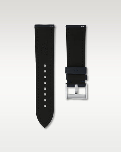 Reverse side view of a 24mm midnight blue sailcloth watch strap showing integrated quick-release spring levers, dark lining, and engraved buckle