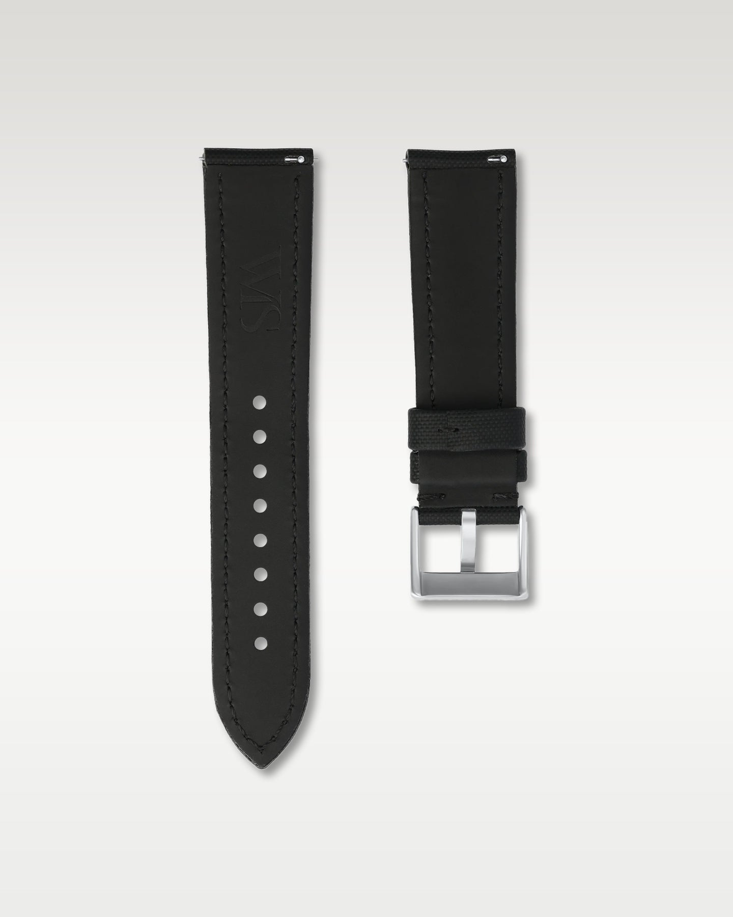 Reverse side of a 22mm black sailcloth watch strap showing integrated quick-release spring levers, dark lining, and engraved buckle